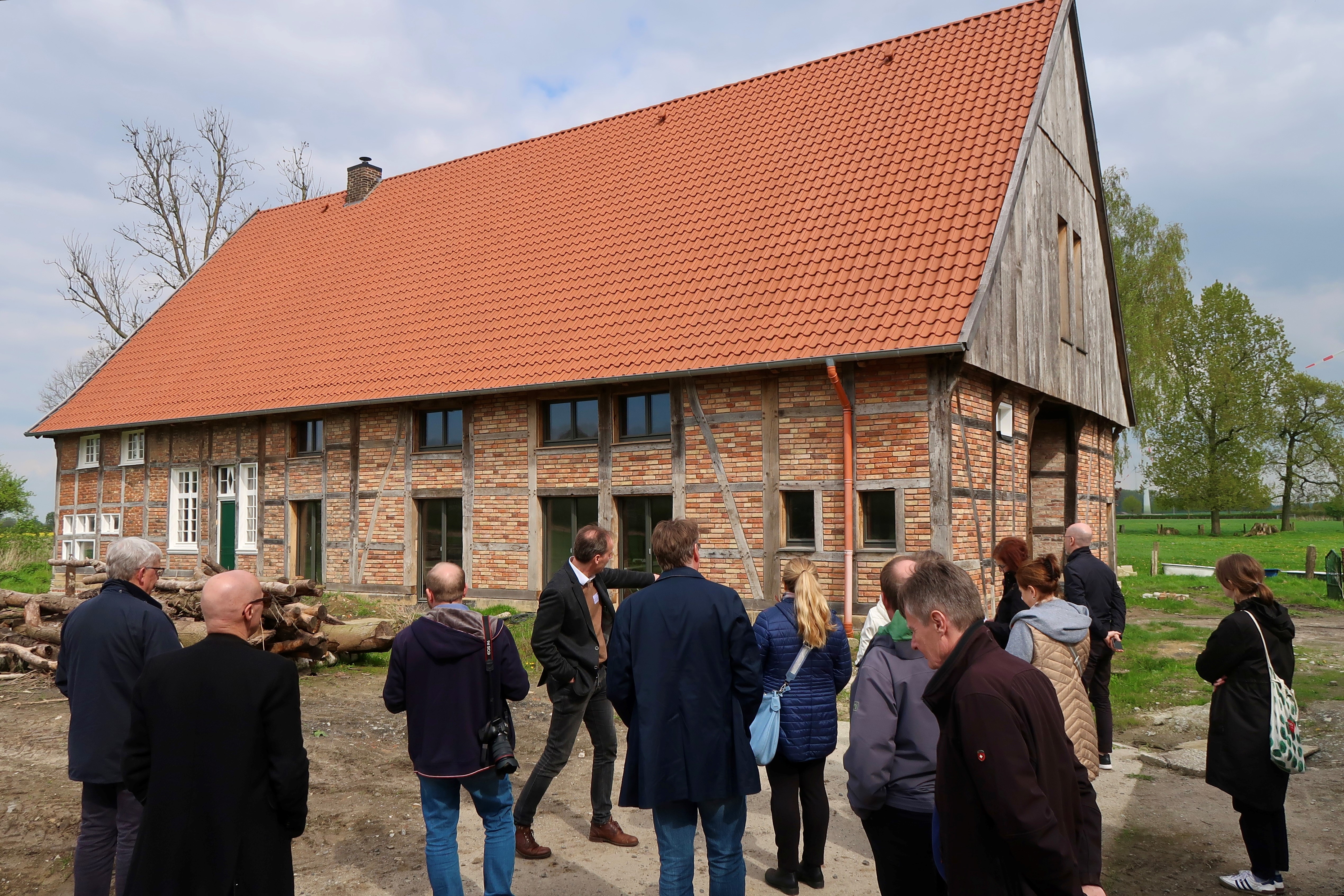 Teilnehmende vor einem der umgebauten Bauernhäuser