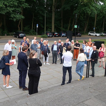 Teilnehmende des Hausbesuchs bei der Begrüßung auf dem Vorplatz vom Museumszentrum