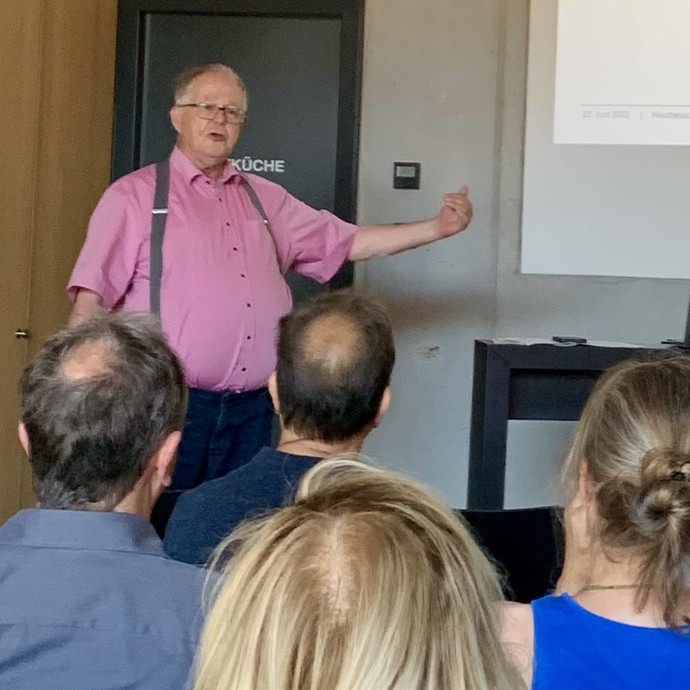 Referent Prof. Wolfgang Fiegenbaum spricht vor den Teilnehmenden des Hausbesuches (vergrößerte Bildansicht wird geöffnet)