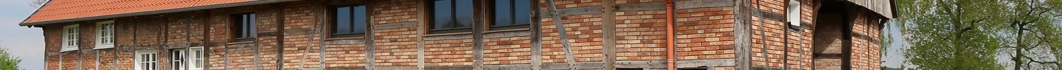 Teilnehmende vor einem der umgebauten Bauernhäuser