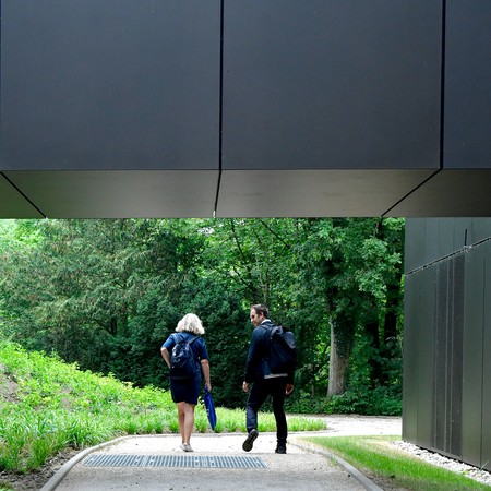 Zwei Teilnehmende des Hausbesuchs unter der Verbindungsbrücke zum Erweiterungsbau vom Museumszentrum